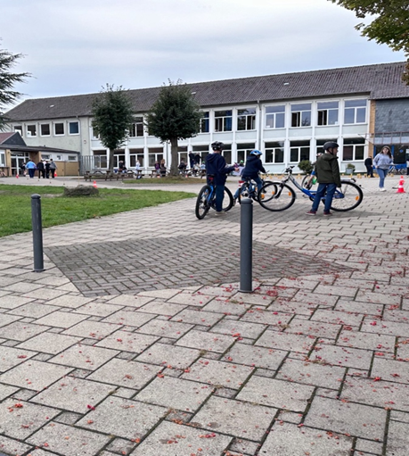 Mehrere SchülerInnen stehen mit ihren Fahrrädern am Parkour und warten zu starten